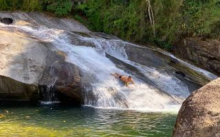 Homem desce de barriga na Cachoeira do Escorrega em Visconde de Mauá