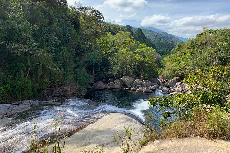 Vista de cima da Cachoeira do Escorrega com árvores e pedras em Visconde de Mauá