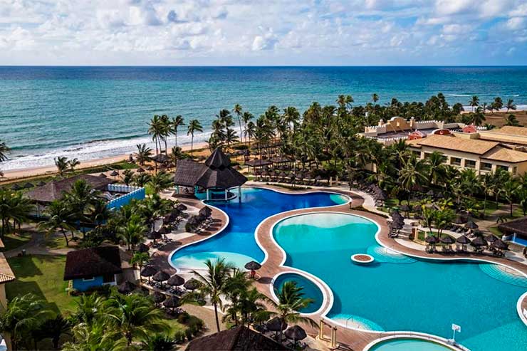 Piscinas e área externa do Iberostar Bahia em frente ao mar em dia de céu azul