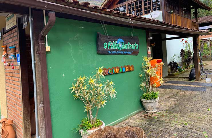 Entrada do restaurante O Filho da Truta, no Vale do Pavão, em tons esverdeados