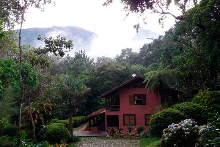 Parte externa da Giramundo com jardim e montanha ao fundo