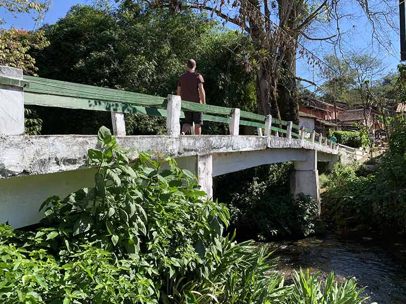 Homem atravessando ponte na Vila de Maringá entre Rio e Minas Gerais
