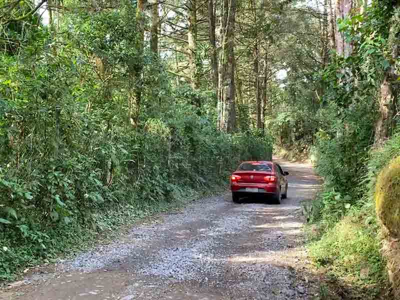 Carro vermelho em estrada de terra da Cachoeira de Santa Clara, em Bocaina de Minas