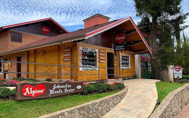 Entrada da loja Alpina, que vende sabonetes, em dia de céu azul