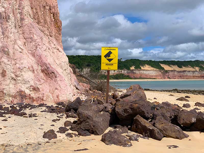 Placa indica para tomar cuidado com falésias em praia no RN