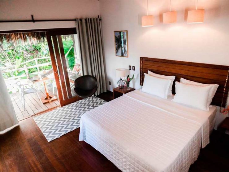 Quarto do  Madeiro Beach Hotel com cama de casal com roupas brancas e varanda
