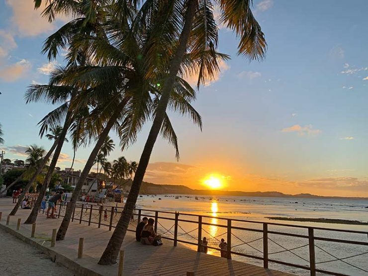 Pôr do sol e coqueiros na orla da praia do Centro em Pipa