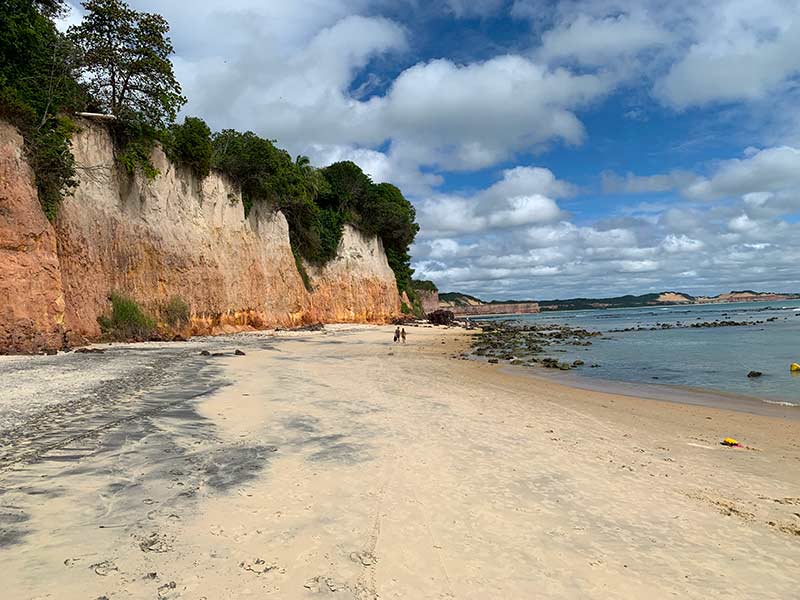 Falésias na Praia do Centro, em Pipa, com mar e céu com nuvens