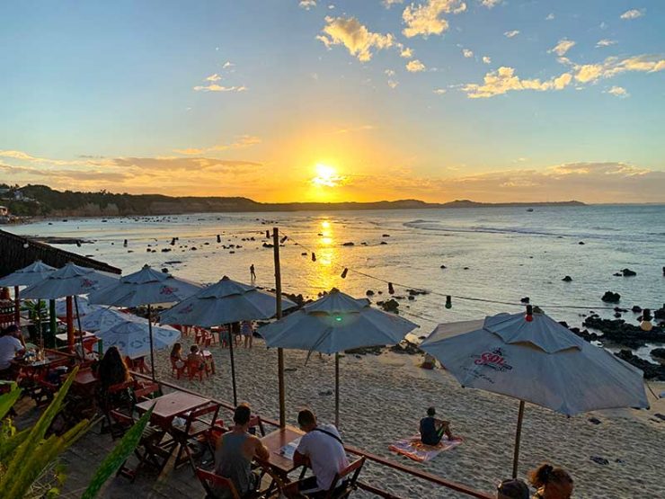 Pessoas assistem ao pôr do sol no Orishas, bar na Praia do Centro