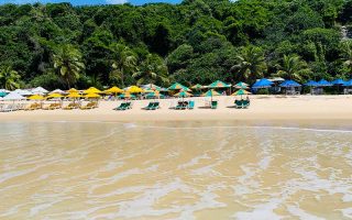 Barracas de praias e espreguiçadeiras na areia da Praia do Madeiro em Pipa vistas do mar