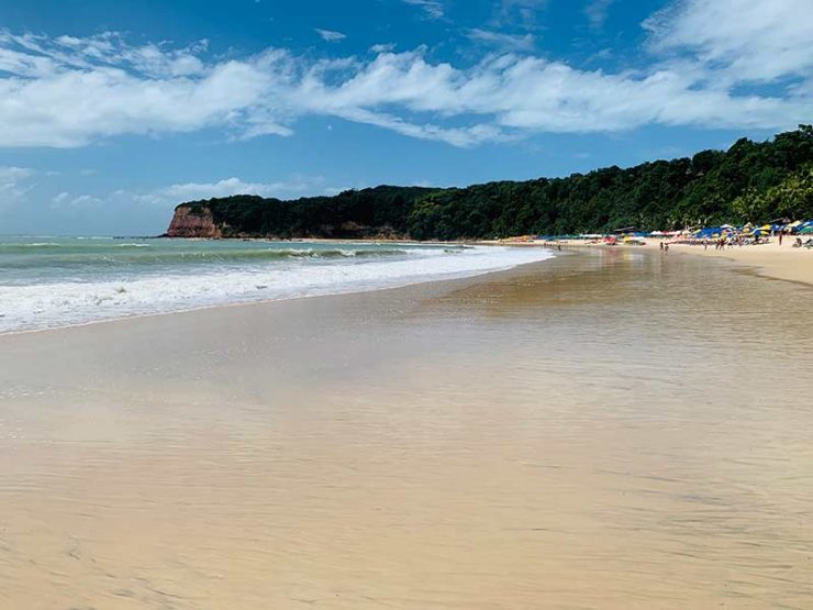 Praia do Madeiro com mar e faixa de areia vazios