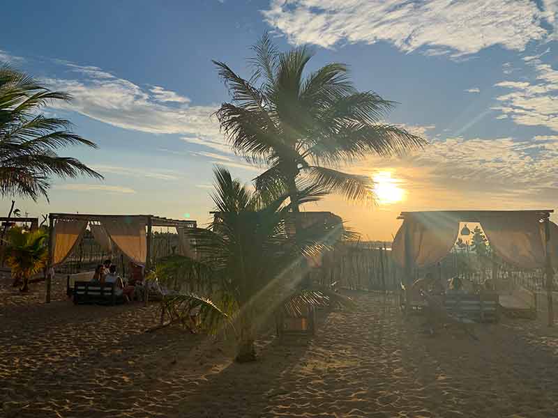 Pôr do sol no Idílico, na praia de  Monte Alegre, com coqueiros e barracas