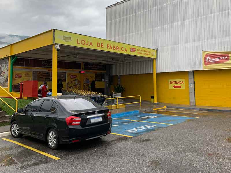 Carro preto parado em frente à entrada do outlet da Bauducco em Extrema, Minas Gerais