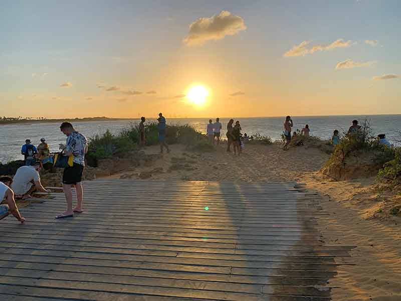 Pessoas veem o pôr do sol em plataforma de madeira em Tourinhos
