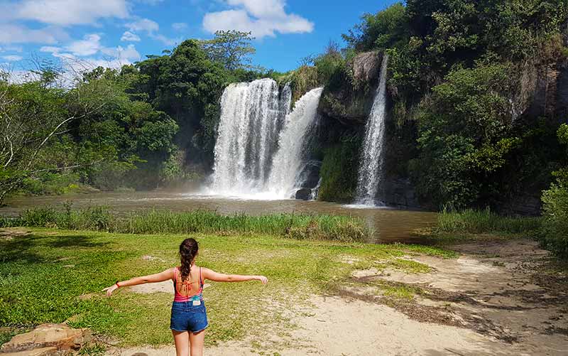 Menina de braços abertos na Cachoeira da Fumaça em Carrancas