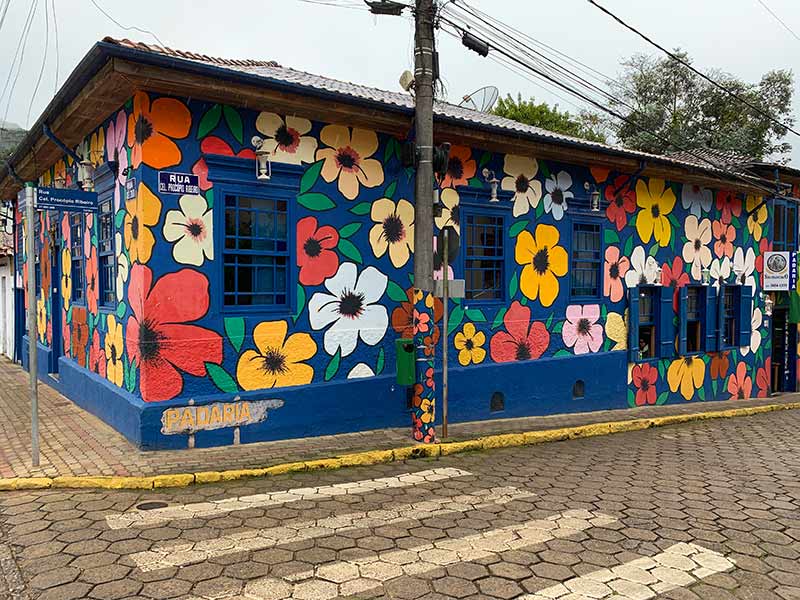 Parte externa da Padaria São Francisco, em Gonçalves, com flores pintadas nos muros