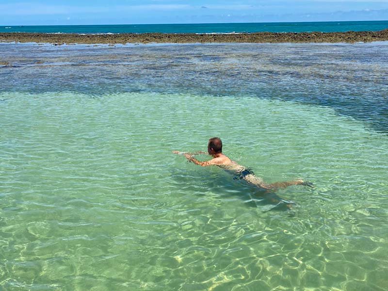 Homem nada nas Piscinas Naturais de Japaratinga