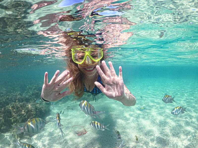 Mulher mergulha no mar cristalino de Japaratinga