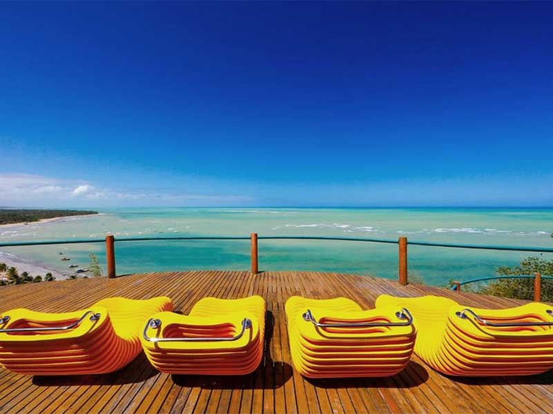 Cadeiras amarelas com vista pro mar na Pousada do Alto