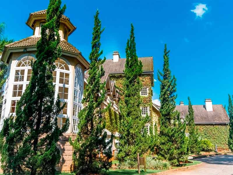 Área externa do Recanto da Paz, um dos melhores hotéis em Atibaia, com árvores em dia de céu azul