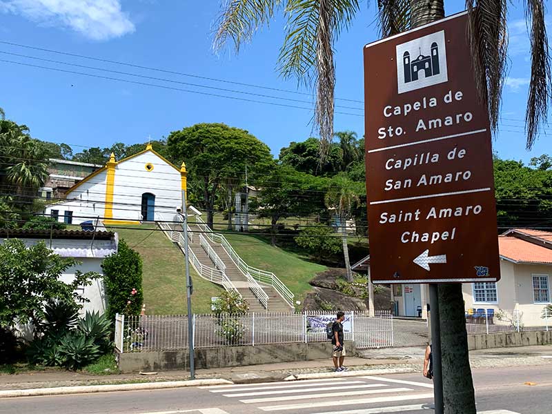 Parte externa da Capela de Santo Amaro, em Balneário Camboriú, com escadas e jardins em dia de céu azul