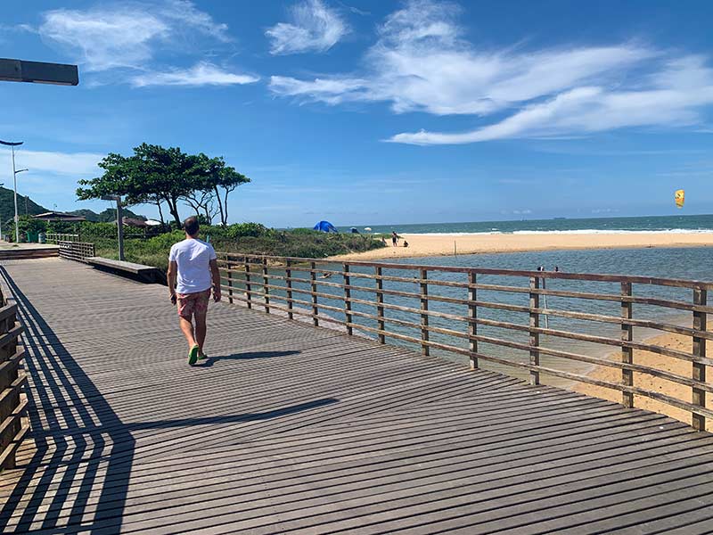 Homem caminha por passarela na praia Brava, em Itajaí, Santa Catarina