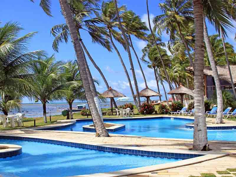 Piscina e coqueiros de frente pro mar no Albacora Praia Hotel