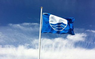 Bandeira azul hasteada em céu azul com algumas nuvens