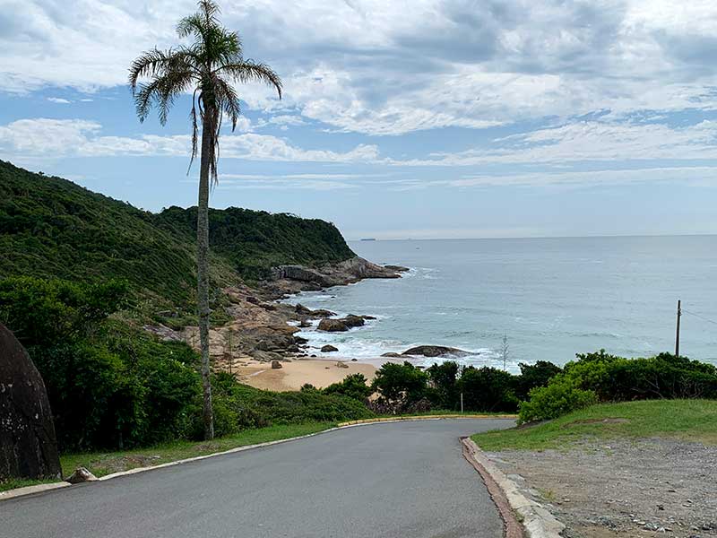 Caminho para a Praia do Pinho, em Balneário Camboriú, em dia de céu com algumas nuvens