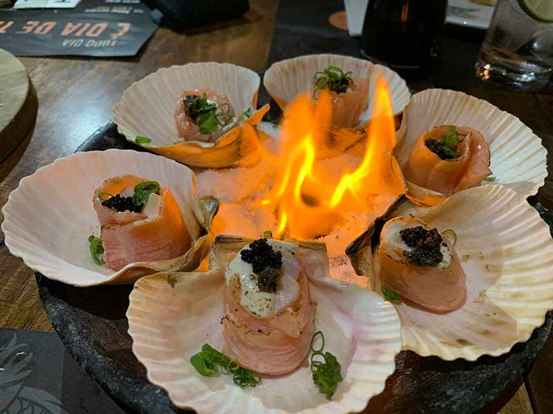 Enrolados de salmão com cream chesse com fogo no meio do restaurante Taj