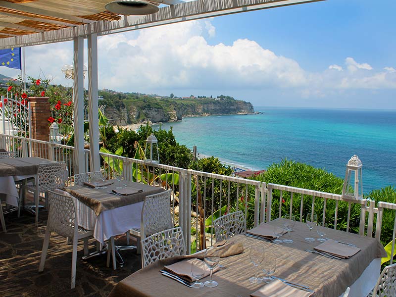 Mesas de restaurante com vista pro Mar de Tirreno, na Itália