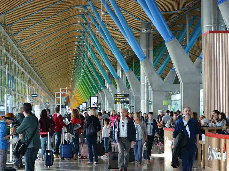 Vários passageiros em frente a portão de embarque no aeroporto de Madrid