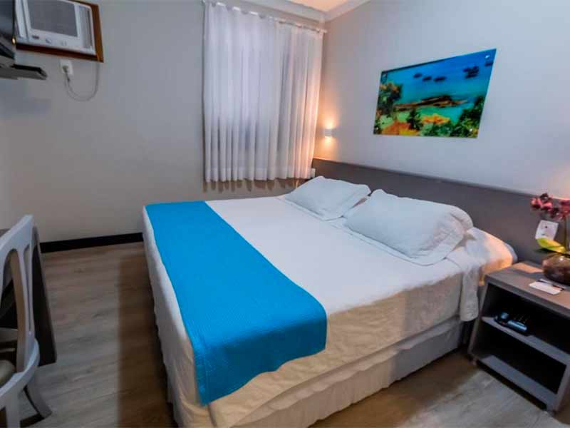 Quarto simples do Camboriú Praia Hotel, dica de onde ficar em Balneário Camboriú, com cama de casal e quadro na parede