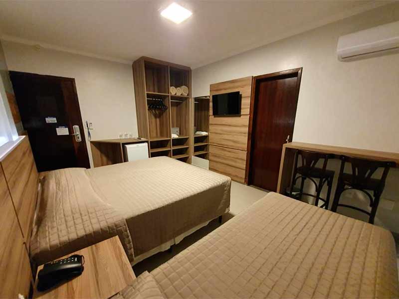 Quarto do hotel Gumz com duas camas e móveis de madeira