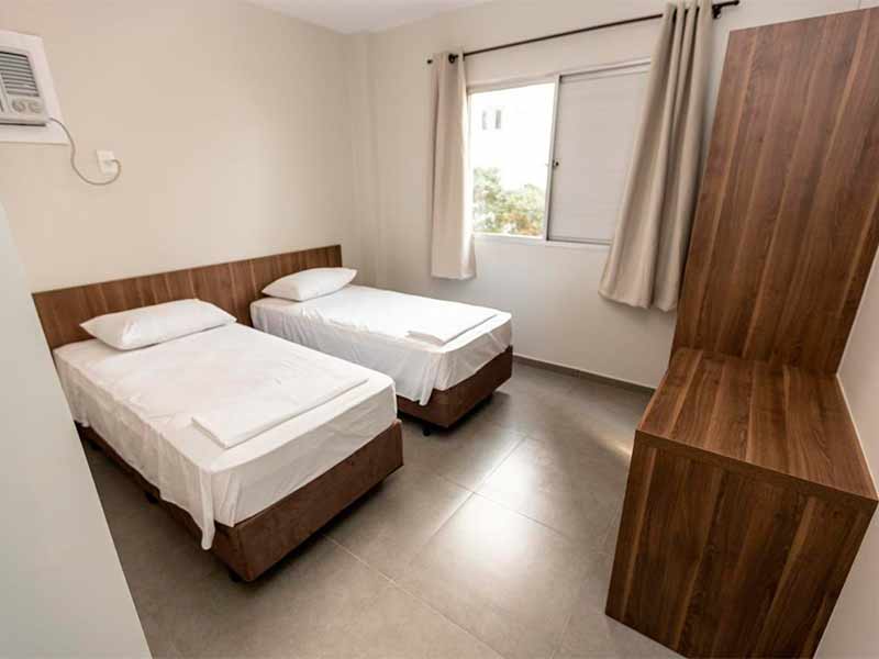 Quarto do Hotel do Bosque, dica de onde ficar em Balneário Camboriú, com duas camas de solteiro e móveis de madeira