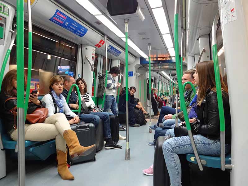 Vagão com passageiros do metrô de Madrid saindo do aeroporto