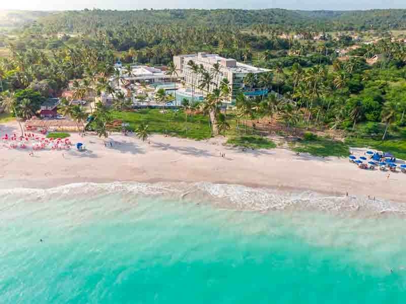 Vista aérea do Maragogi Brisa Exclusive, uma das pousadas na Praia de Antunes, com mar esverdeado