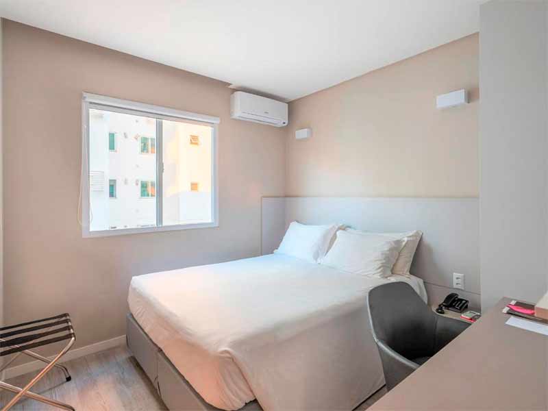 Quarto claro com cama de casal do Hotel Melo, dica de hotel em Balneário Camboriú