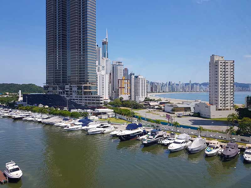Vista da Marina Tedesco com prédios e barcos parados em Balneário Camboriú