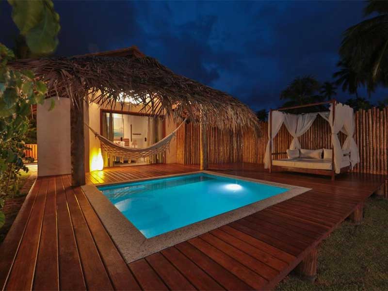 Piscina em frente a chalé durante à noite na Pousada Samba Pa Ti