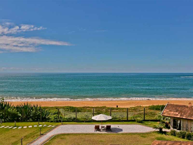 Espreguiçadeiras vazias com guarda-sol em frente ao mar na Praia do Esteleiro Guest House, dica de hotel em Balneário Camboriú