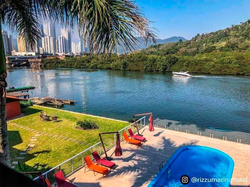 Piscina vazia do Rizzu, hotel em Balneário Camboriú, com vista para o rio e espreguiçadeiras vazias