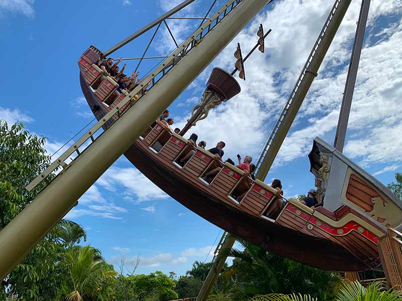 Pessoas se divertem no Barco Pirata em dia de céu com poucas nuvens no Beto Carrero