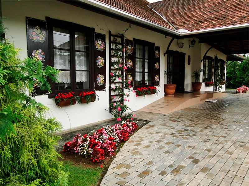 Área externa da Blauberg com muitas flores e jardim