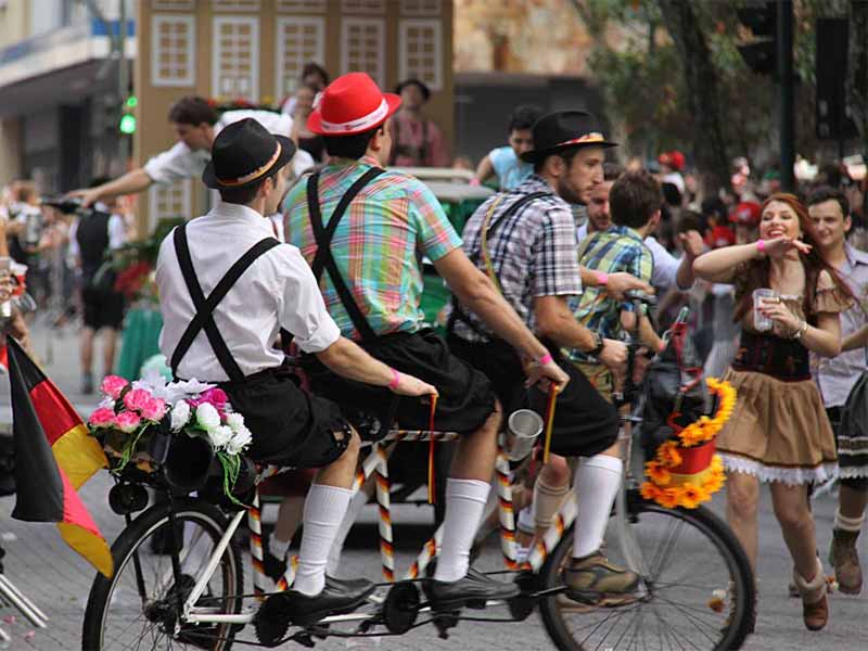 Ciclistas na Oktoberfest com traje típico alemão em Blumenau