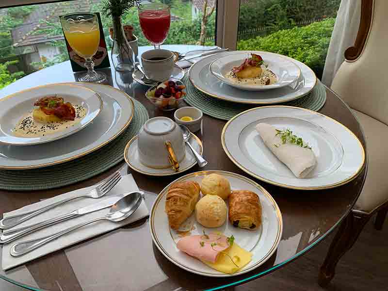 Pães, ovos, tapioca e sucos no café da manhã do Villa do Vale Boutique Hotel, dica do que fazer em Blumenau