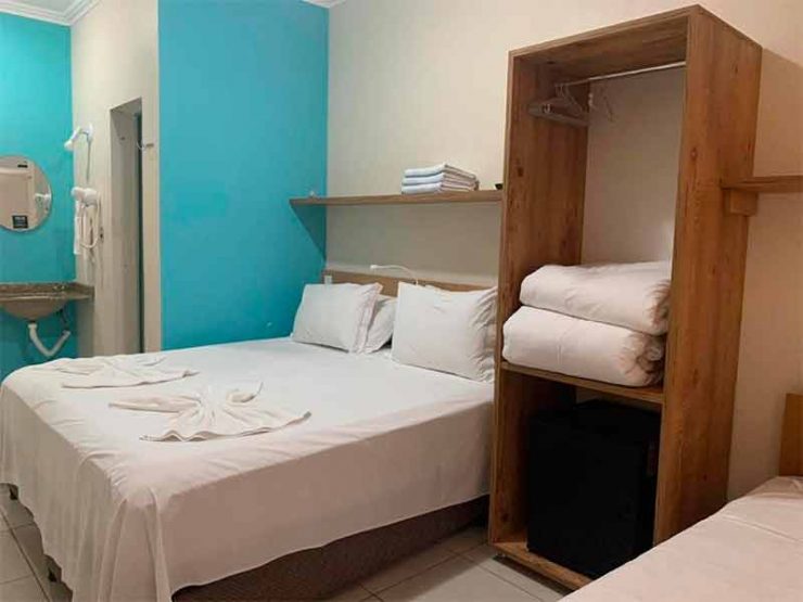 Quarto do Hotel Fazenda Pommernland com cama de casal e parede azul