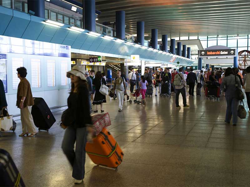 Mulher com mala no aeroporto de Roma antes da imigração na Itália