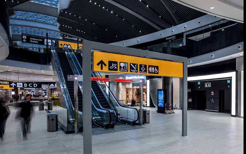 Imigração na Itália: Área de trânsito do aeroporto de Roma com escadas rolantes
