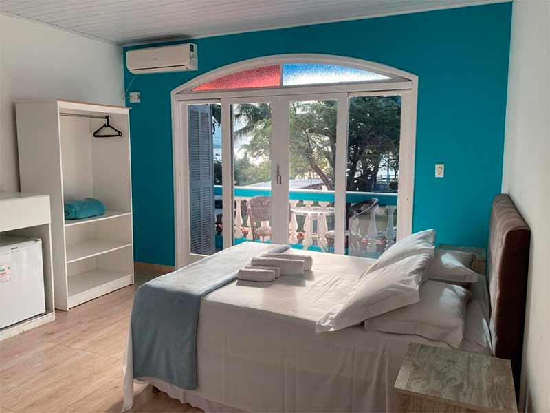 Quarto da pousada Marinamarela com parede azul e cama de casal